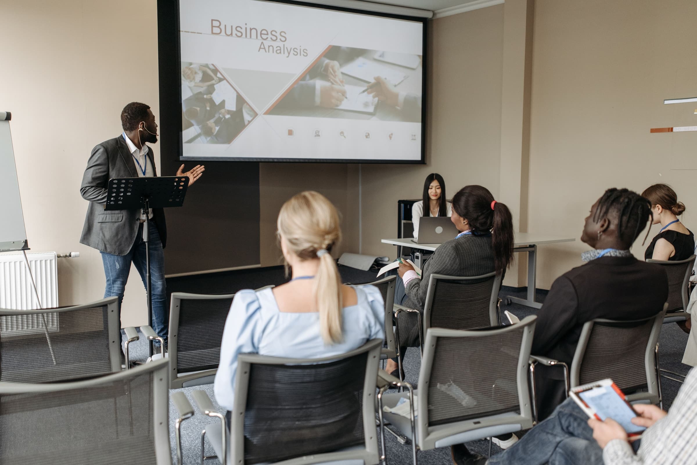 Facilitador conduzindo um treinamento empresarial para um grupo de participantes em uma sala de reunião
